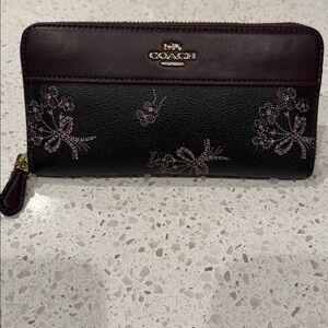Coach black and burgundy floral zip-around wallet.